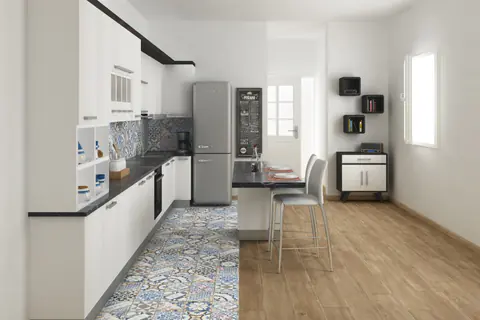 Cucina con pavimento in cementine decorate bianche e blu che lascia il posto a un pavimento effetto legno nella zona pranzo