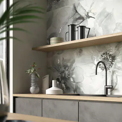 Parete della cucina con mensola in legno e piastrella di grande formato con decoro floreale in grigi sfumati